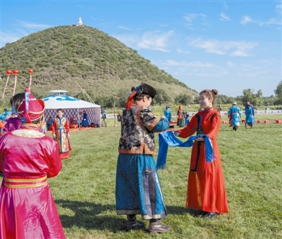 迎亲队伍到达后,女方家向来宾献哈达敬酒.