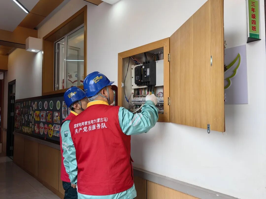 国家电网蒙东电力(通辽城西)蒙古马共产党员服务队队员检查学校走廊配电箱。.png